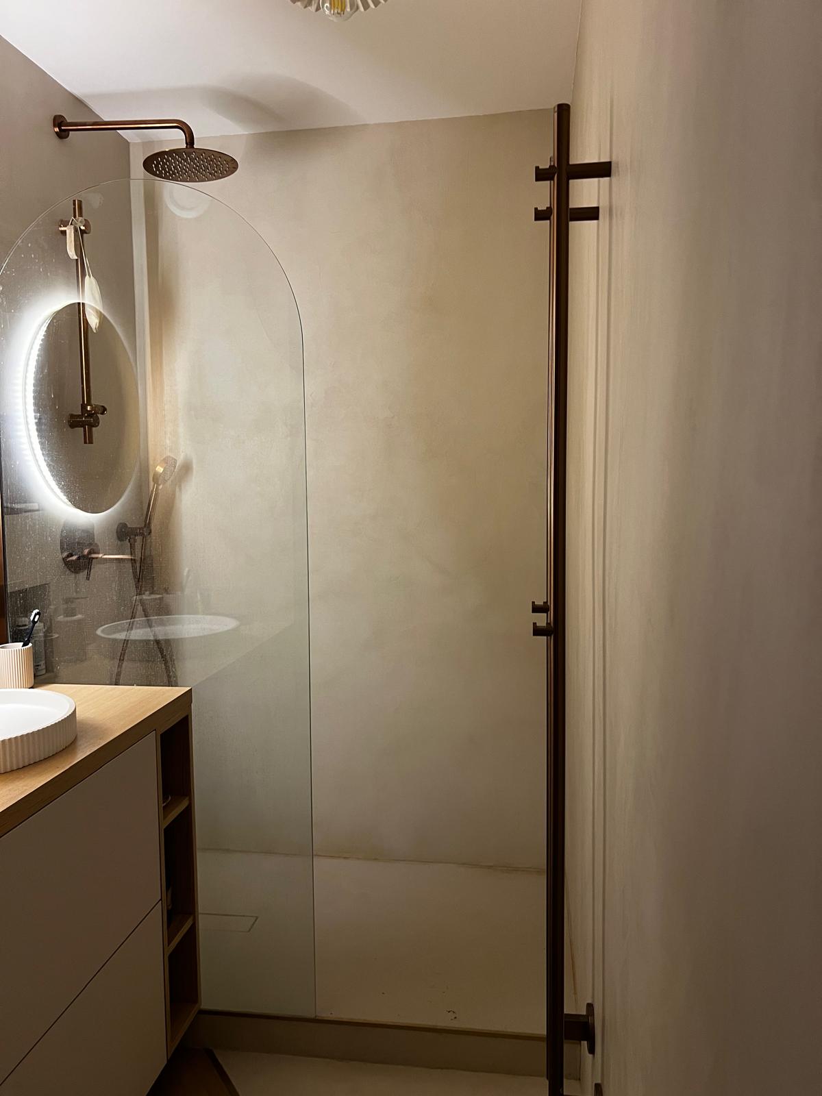 Salle de bain avec douche à l'italienne et robinetterie cuivrée